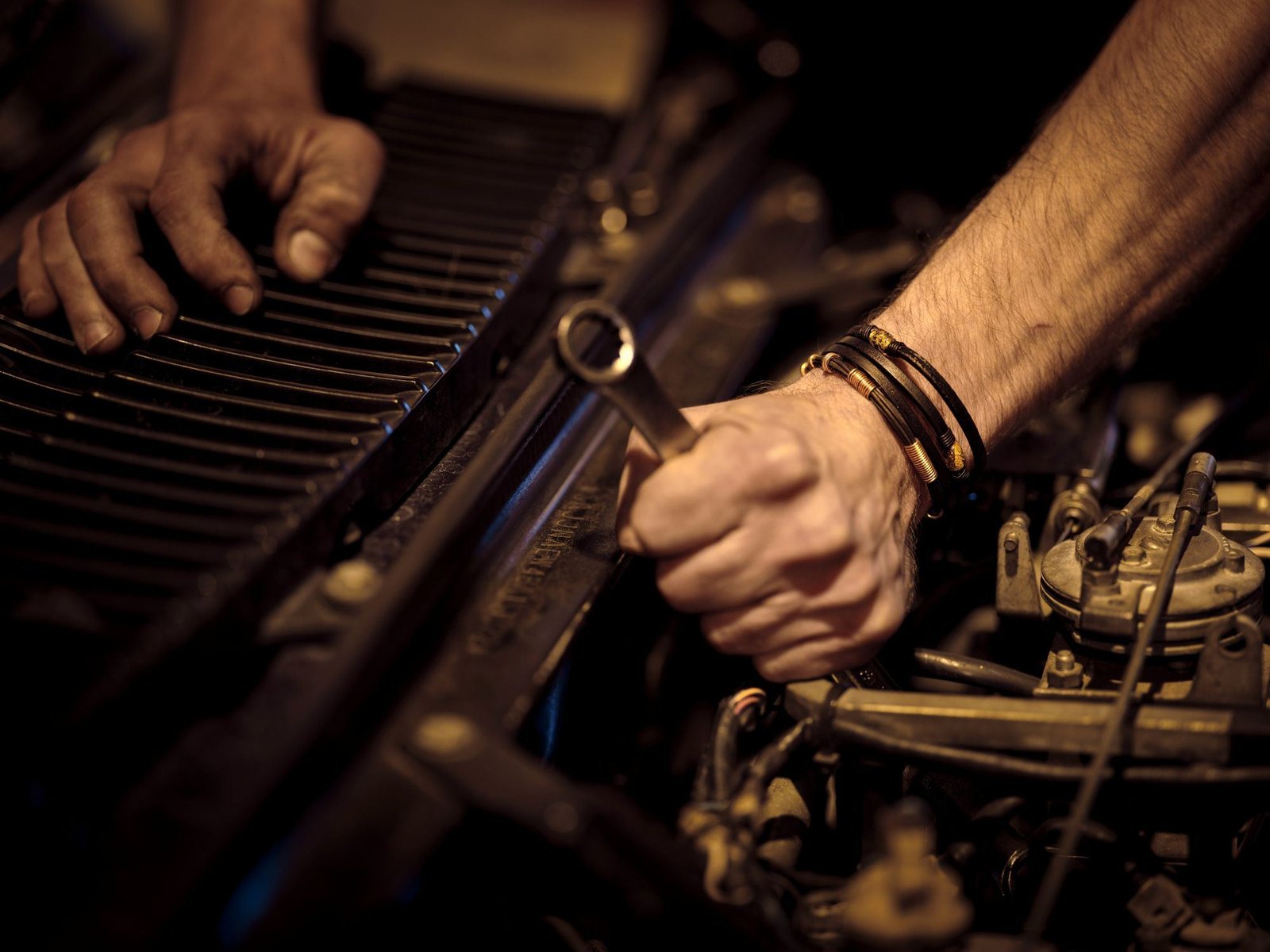 Photo – mechanic tightening a bolt in a car engine bay